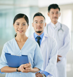 nurse and two doctors smile on the camera