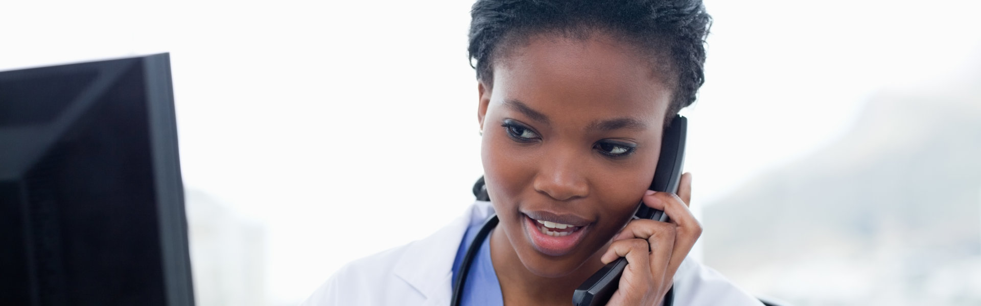 Female doctor on the phone while using a computer